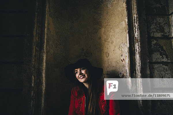 Porträt einer lächelnden kaukasischen Frau  die sich in einer Nische anlehnt