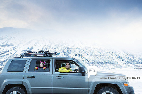 Freunde genießen die Aussicht aus dem Auto im Winter