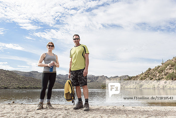 Portrait of smiling hikers standing at lake