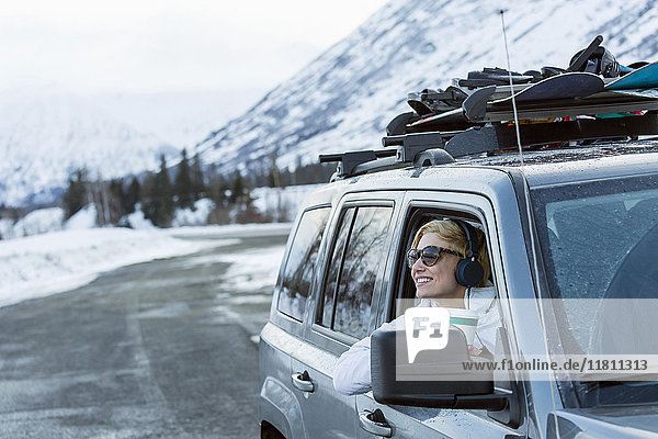 Kaukasische Frau lehnt sich im Winter ins Autofenster