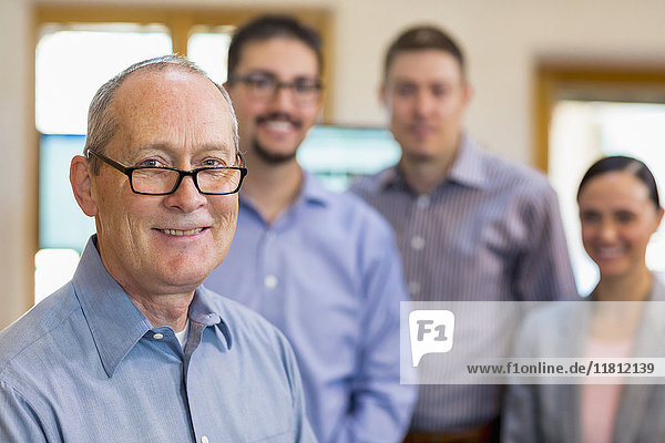 Portrait of smiling businessman and team