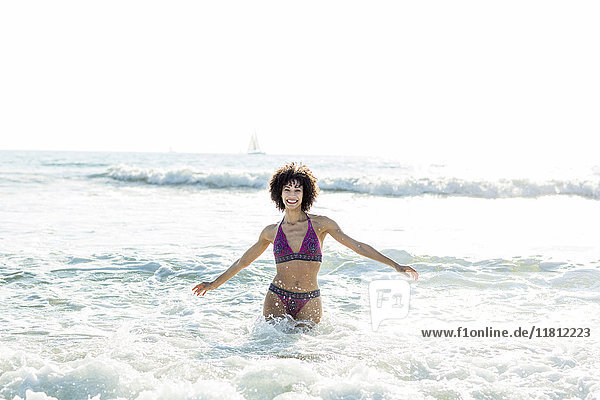 Ocean waves splashing on Mixed Race woman