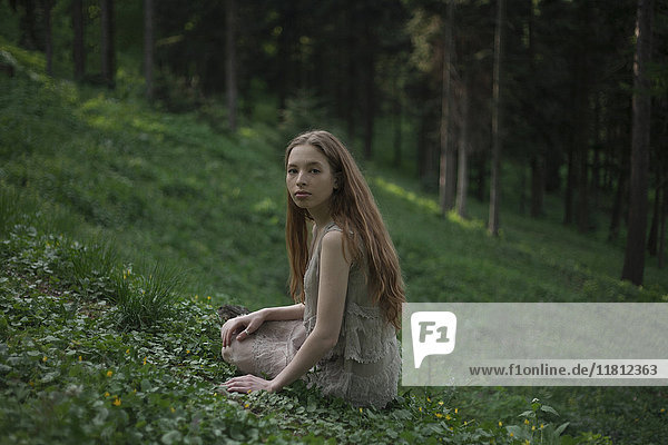 Ernste kaukasische Frau sitzt auf einem Hügel