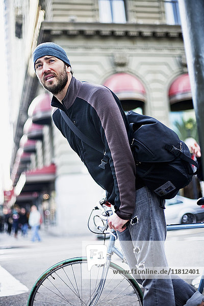 Kaukasischer Mann fährt Fahrrad in der Stadt