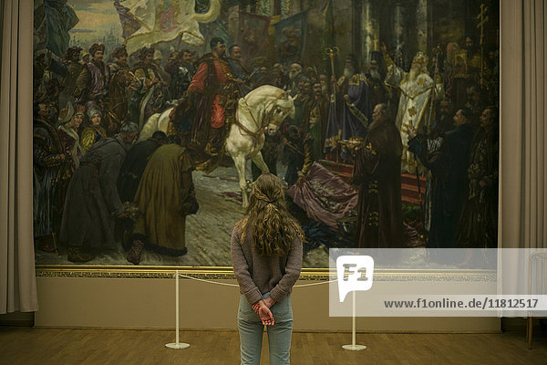 Kaukasisches Teenager-Mädchen bewundert Gemälde im Museum