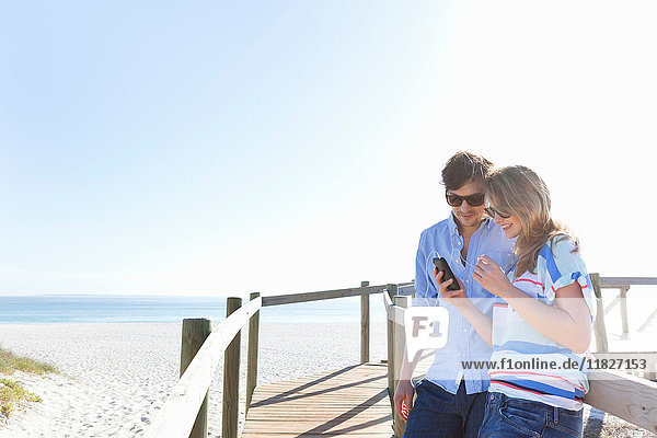 Paar auf der Strandpromenade mit Mobiltelefon