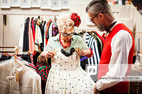 Schrullige Vintage-Frau probiert Kleid in Antiquitäten- und Vintage-Laden aus