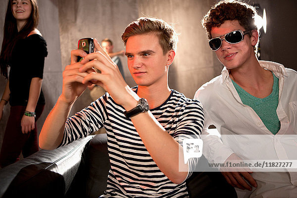 Young men in nightclub taking photograph