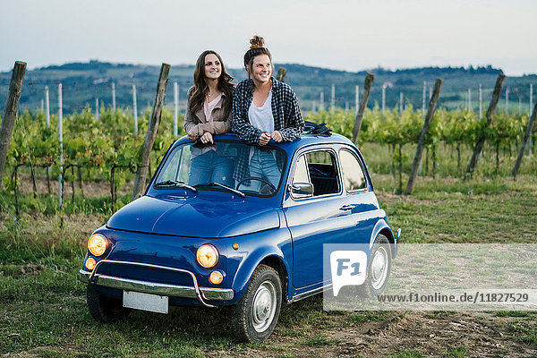 Tourists standing through car sunroof  vineyard  Tuscany  Italy