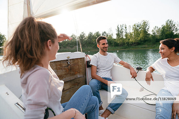 Drei Freunde entspannen sich auf einem Segelboot auf dem See