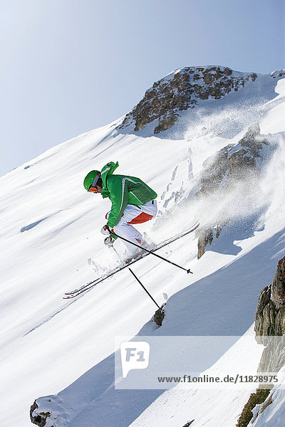 Skifahrer springt vom Fels