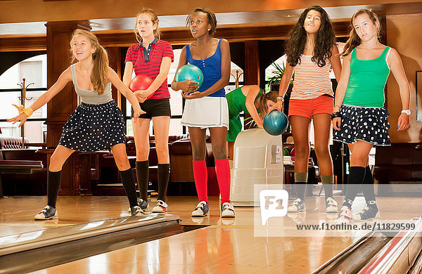 Teenage girls bowling together