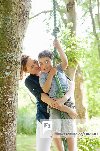 Mother holding son on rope swing