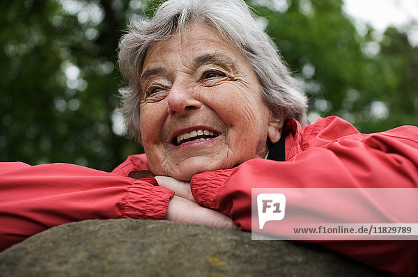 Older woman resting on rock in park