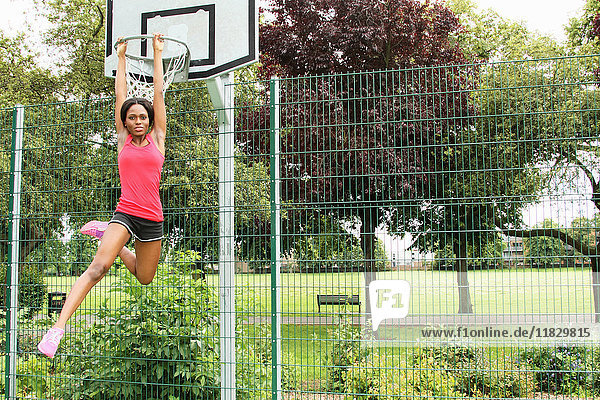 Frau hängt am Basketballnetz