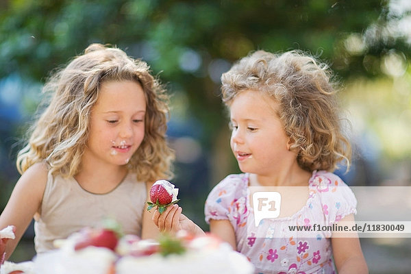 Mädchen essen Erdbeeren im Freien