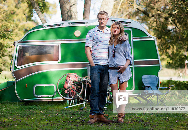 Paar steht vor einem Wohnwagen im Park