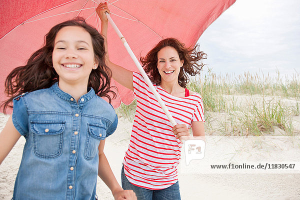 Mother and daughter carrying umbrella