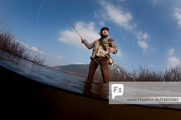 Low angle view of man fishing in lake