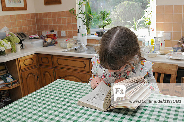 Mädchen liest am Küchentisch