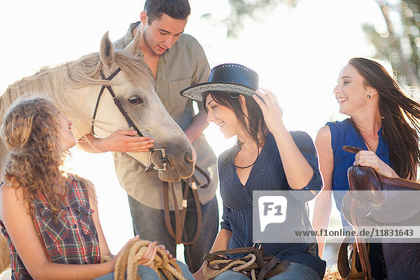Vier junge Freunde mit Pferd