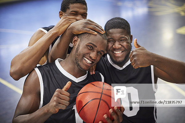 Portrait lächelndes  selbstbewusstes  junges Basketballteam feiert  Daumen hoch gestikulierend