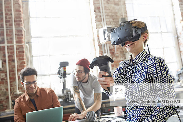 Designerinnen texten Virtual-Reality-Simulator-Brille und verwenden Joystick in der Werkstatt