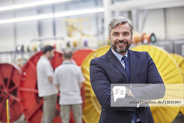 Portrait smiling  confident businessman in fiber optics factory