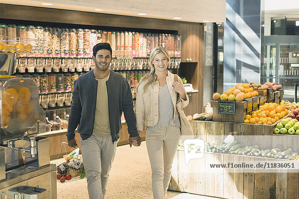 Porträt junges Paar  das sich an den Händen hält  Einkaufen auf dem Markt