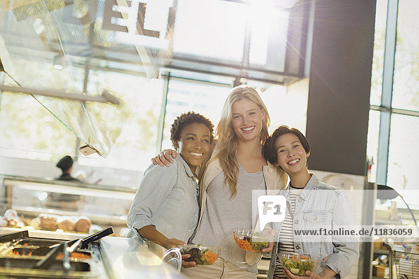 Portrait smiling young women enjoying salad bar at grocery store market