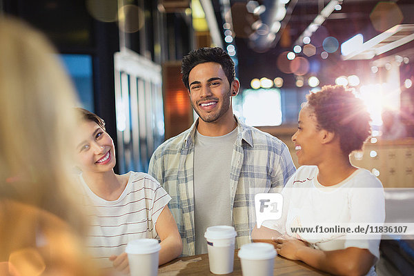 Lächelnde junge Freunde trinken Kaffee im Café