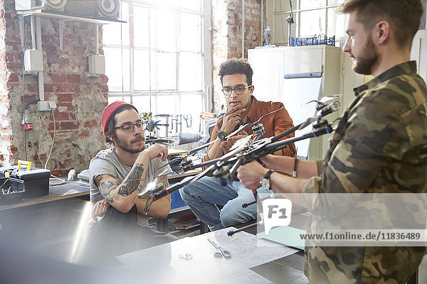 Designers meeting  examining drone in workshop