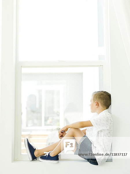 Boy (6-7) looking through window