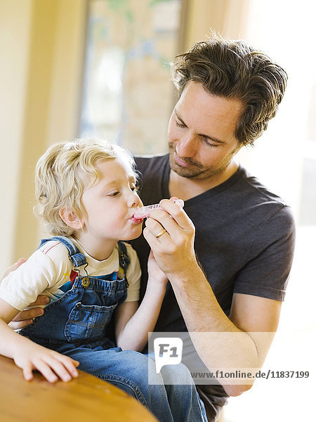 Father applying medicine to son (4-5)