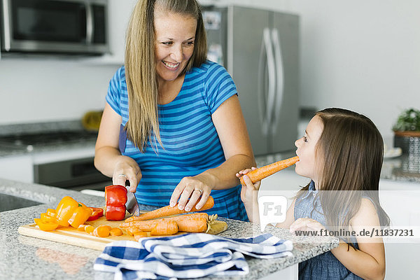 Mutter kocht mit Tochter (6-7) in der Küche