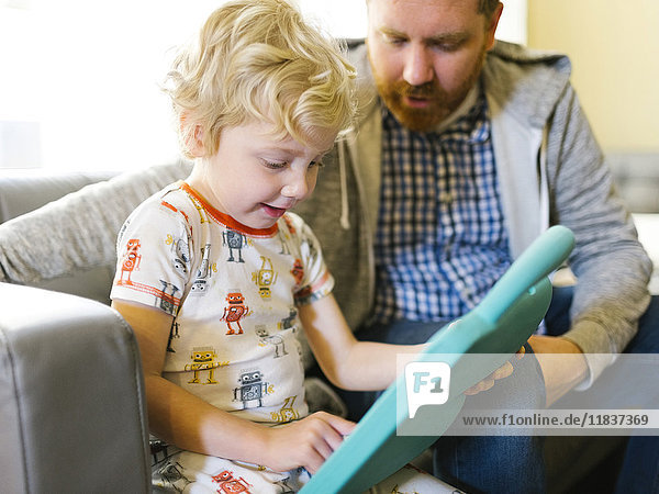 Vater und Sohn (4-5) spielen mit elektronischem Spielzeug