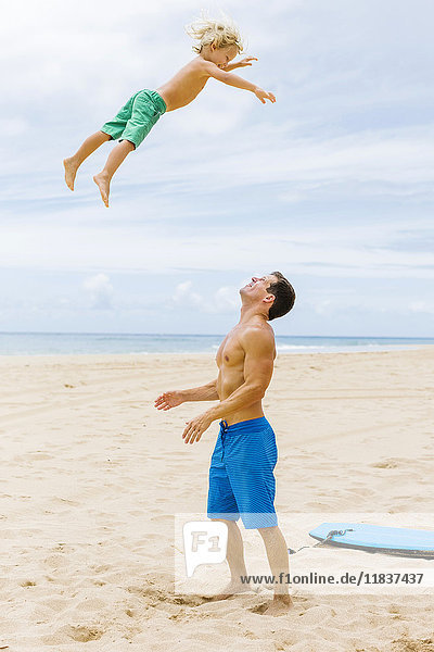 Vater mit Sohn (4-5) beim Spielen am Strand