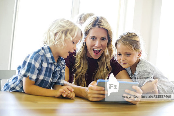 Mutter mit Kindern (4-5  6-7  8-9)  die ein digitales Tablet benutzen