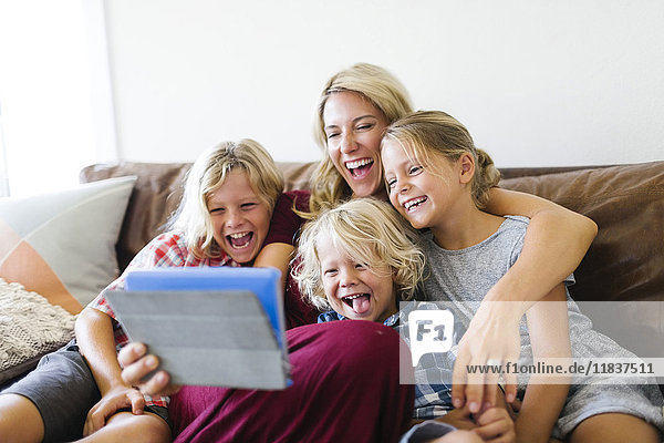 Mutter und Kinder (4-5  6-7  8-9) machen ein Selfie mit einem digitalen Tablet