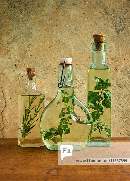 Olivenölflaschen mit Minze  Rosmarin und Oreganoblättern