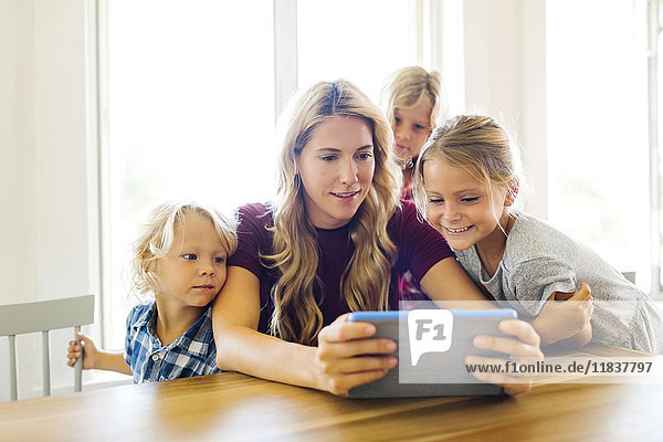 Mutter und Kinder (4-5  6-7  8-9) mit digitalem Tablet