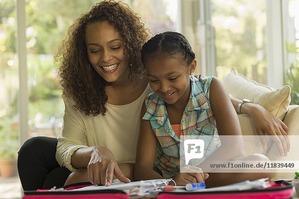 Afroamerikanische Mutter hilft ihrer Tochter bei den Hausaufgaben
