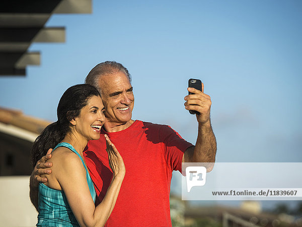 Älteres Paar winkt und posiert für Handy-Selfie
