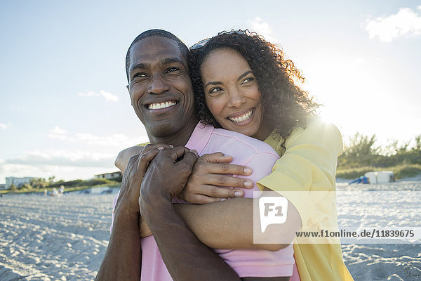 Porträt eines lächelnden Paares  das sich am Strand umarmt
