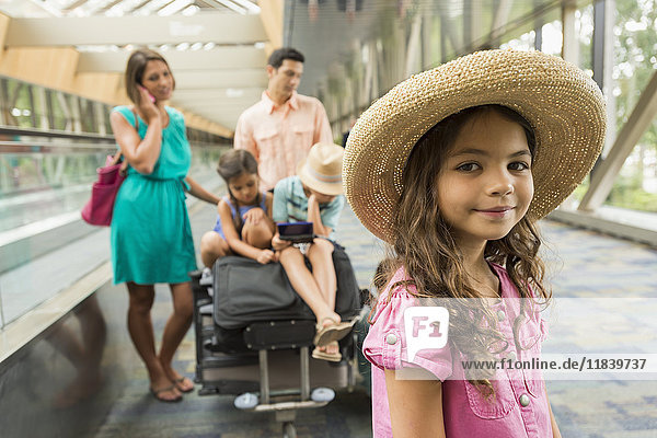 Porträt eines Mädchens  das mit seiner Familie im Flughafen wartet