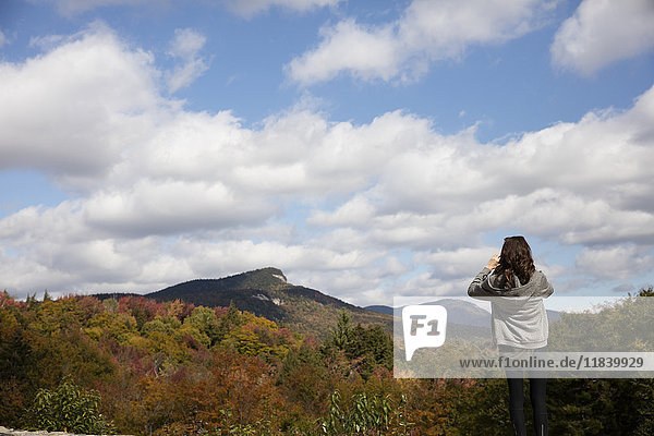 Caucasian woman admiring mountain range in autumn