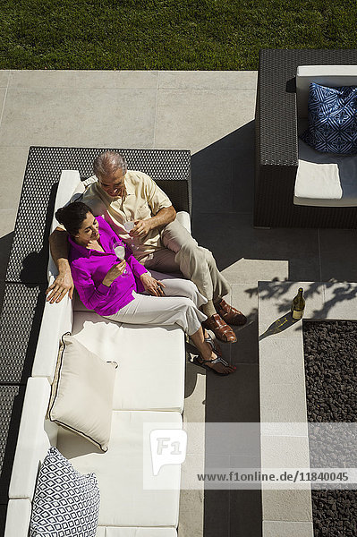 Älteres Paar entspannt sich auf einer modernen Terrasse im Hinterhof