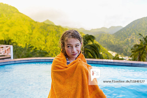 Caucasian girl wrapped in towel near swimming pool