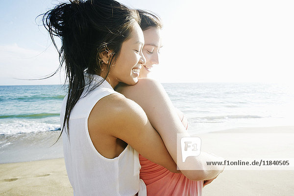 Frauen umarmen sich am Strand