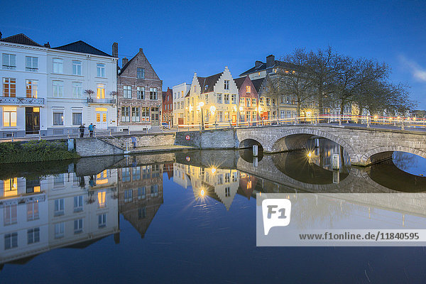 Dusk lights on the historic buildings of the city centre reflected in typical canals  Bruges  West Flanders  Belgium  Europe